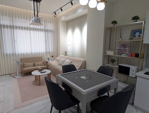 A modern living room with a sofa, a dining table with chairs, a coffee table, and a TV. - Wujie, Yilan private villa, ideal for families, friends and group stays. (Yilan County)