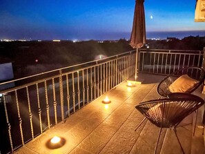 A balcony with a railing, two chairs, and candles. - Nicolina by Interhome (Poreč/Kaštelir)