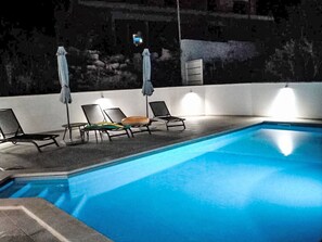 Una piscina amb gandules i ombrelles.