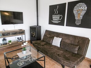 A modern living room with a leather sofa, a glass coffee table, and a flat-screen TV mounted on the wall. - Nicolina by Interhome (Poreč/Kaštelir)