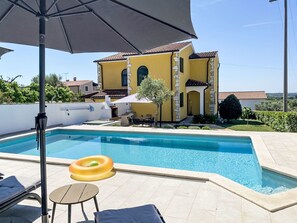 A swimming pool with a lounge area, a yellow building, and a clear sky. - Nicolina by Interhome (Poreč/Kaštelir)