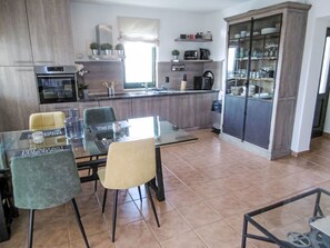A modern kitchen with a dining area, featuring a glass table, chairs, and a built-in oven. - Nicolina by Interhome (Poreč/Kaštelir)