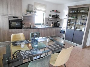 A modern kitchen with a dining table, chairs, and a refrigerator. - Nicolina by Interhome (Poreč/Kaštelir)