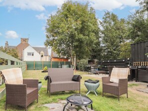 An outdoor seating area with wicker furniture, a grill, and a wooden deck. - Ballinreich by Interhome (Inverness)