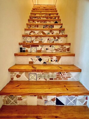 A staircase with wooden steps and mosaic tile accents. - The Terrace Above Main lLarge 4 bedroom House on Main St (Eureka Springs)