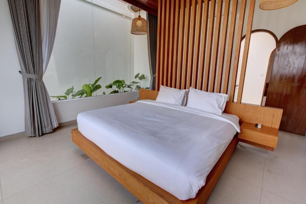 Un dormitorio moderno con un cabecero de madera, una mesita de noche y un ventanal con cortinas.
