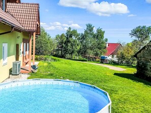 Ein Wohnhaus mit Swimmingpool, Rasenfläche und einem Gebäude mit rotem Dach.