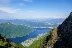 A mountainous landscape with a lake and a town. - Emotion Lake Lugano with direct lake access and shared pool, Capo Lago, Switzerland (Capo Lago)