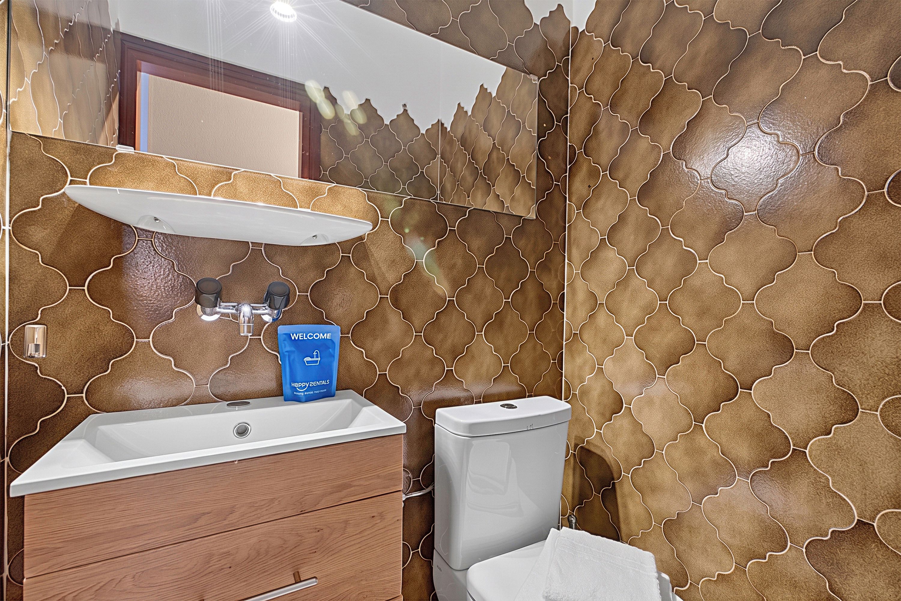 Ein Badezimmer mit Waschbecken, Spiegel und Toilette.