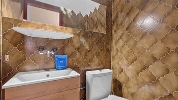 Ein Badezimmer mit Waschbecken, Spiegel und Toilette.