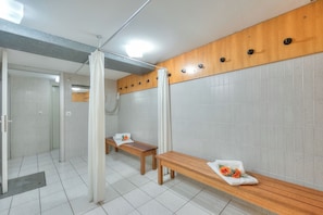A modern bathroom with a bench, a shower area, and a wooden panel wall. - Emotion Lake Lugano with direct lake access and shared pool, Capo Lago, Switzerland (Capo Lago)