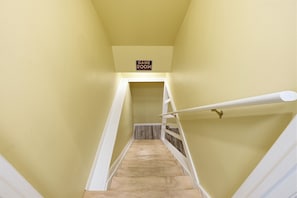 A staircase leading to a room labeled 'GAME ROOM' with a wooden floor and white railings. - The Birch: Poconos Getaway • Hot Tub, Game Room, Fire Pit • Sleeps 10 (Blakeslee)