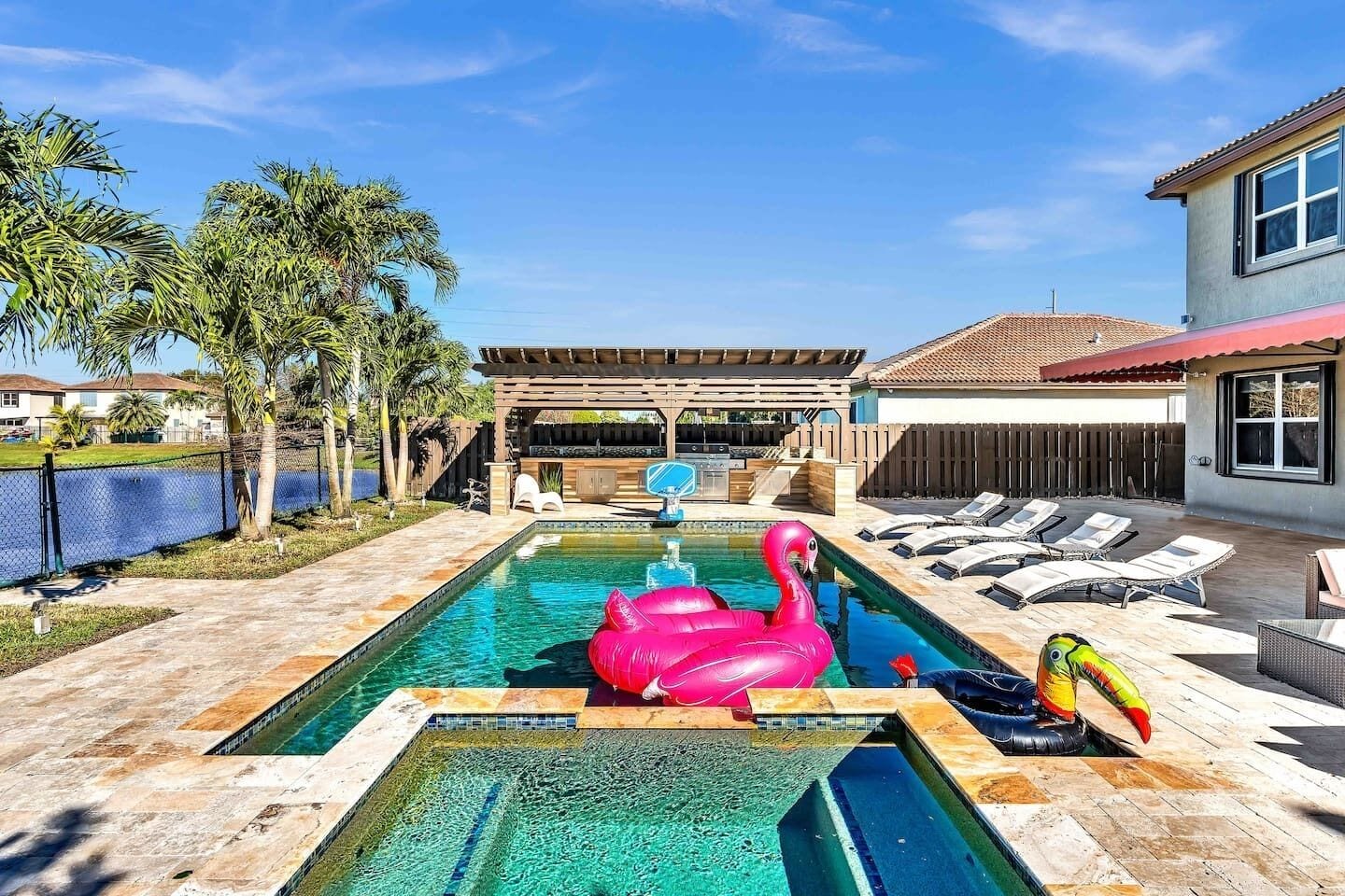 A swimming pool with lounge chairs and a flamingo float.