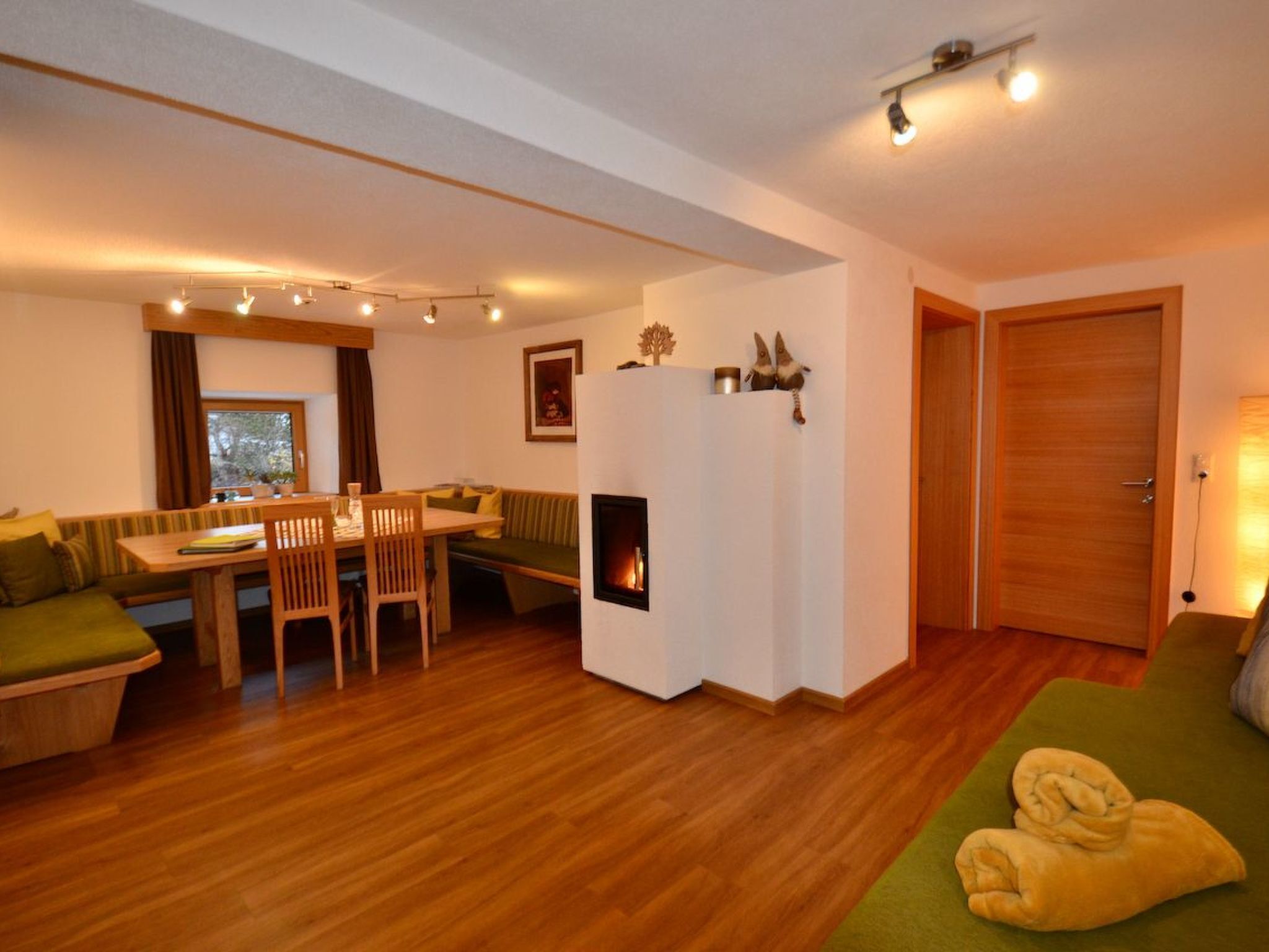 Een gezellige woonkamer met een open haard, houten meubels en een eethoek.