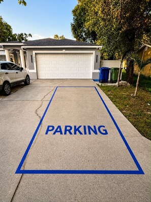 A garage with a blue parking sign on the driveway.