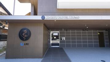 The entrance to Jinryu Hotel Izumo with a modern design, a dragon logo, and a sign for LRE.