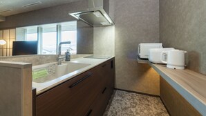 Una cocina moderna con un lavaplatos integrado, una cafetera y un ventanal que aporta luz natural.