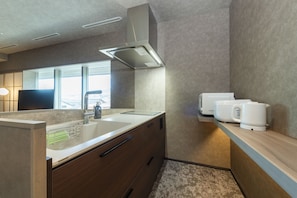 A modern kitchen with a built-in sink, a coffee machine, and a window providing natural light.