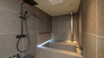 A modern bathroom with a shower, a bathtub, and a shelf with toiletries.