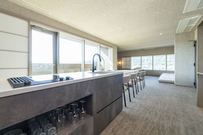 A modern kitchen with a large island, bar stools, and a wine rack.