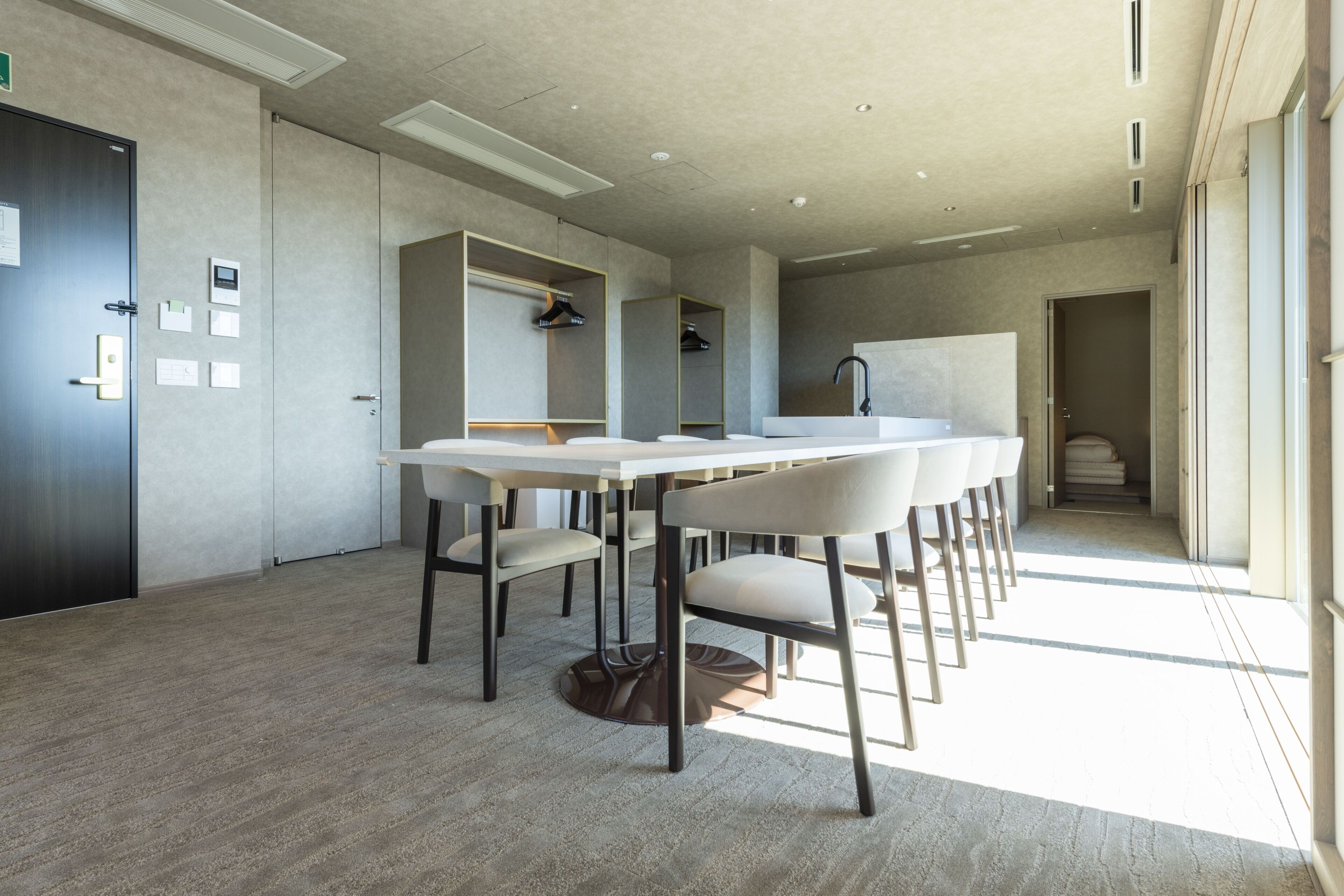 A modern conference room with a long table, chairs, and a whiteboard.