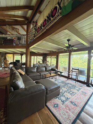 A spacious living area with a large sectional sofa, a wooden coffee table, and a patterned rug.