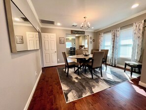 A dining area with a wooden table, chairs, and a chandelier.