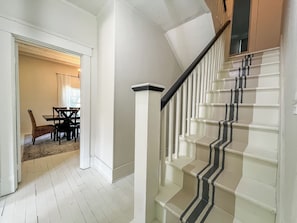 A staircase with a black and white striped handrail and white steps.