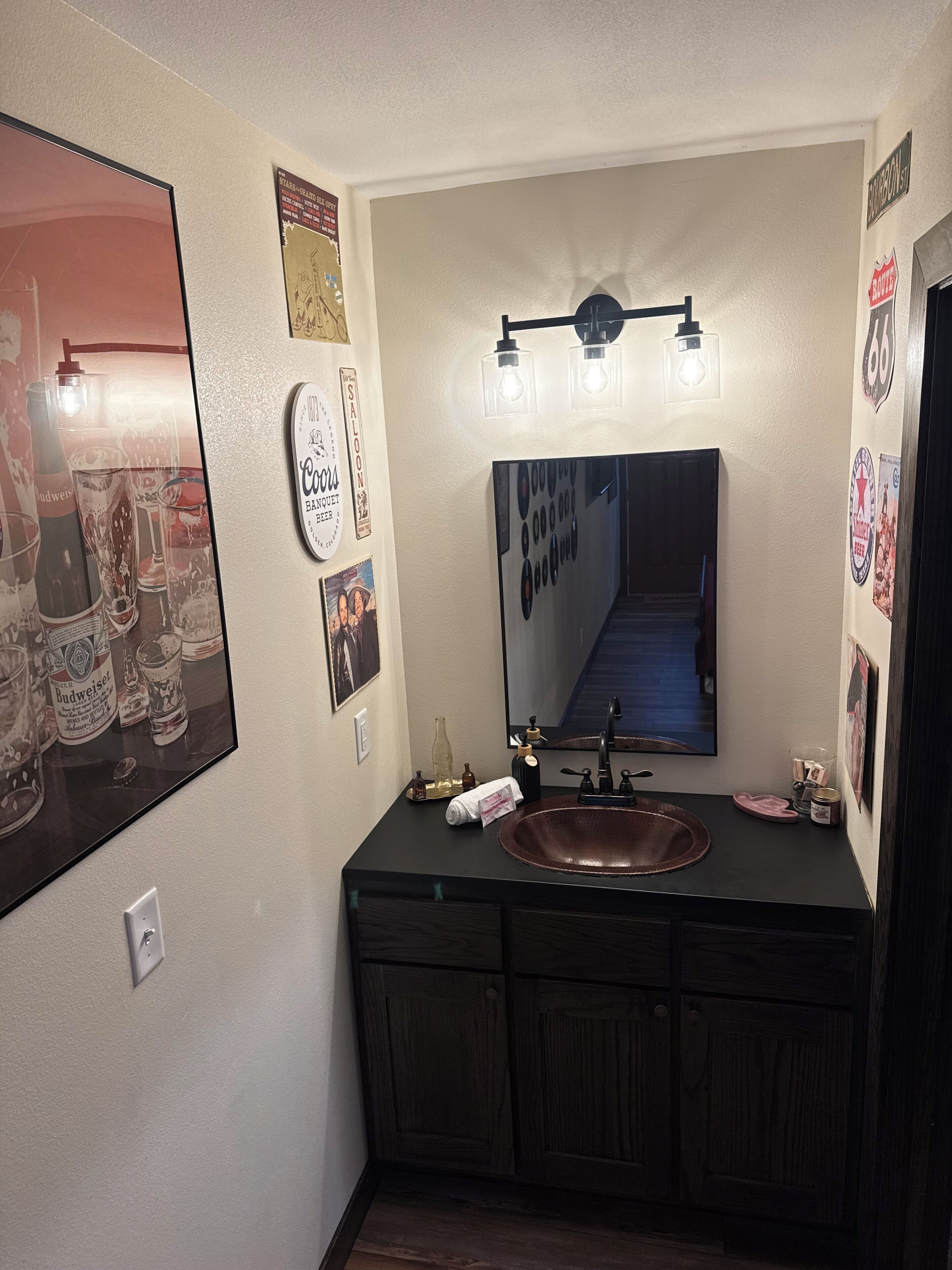Un baño con un espejo grande, un lavamanos y un mueble de tocador con armarios.