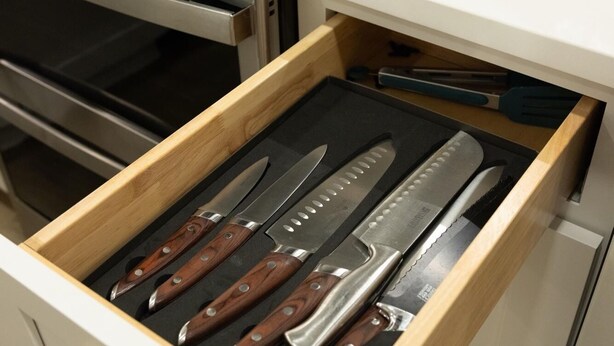A kitchen drawer with a set of knives.