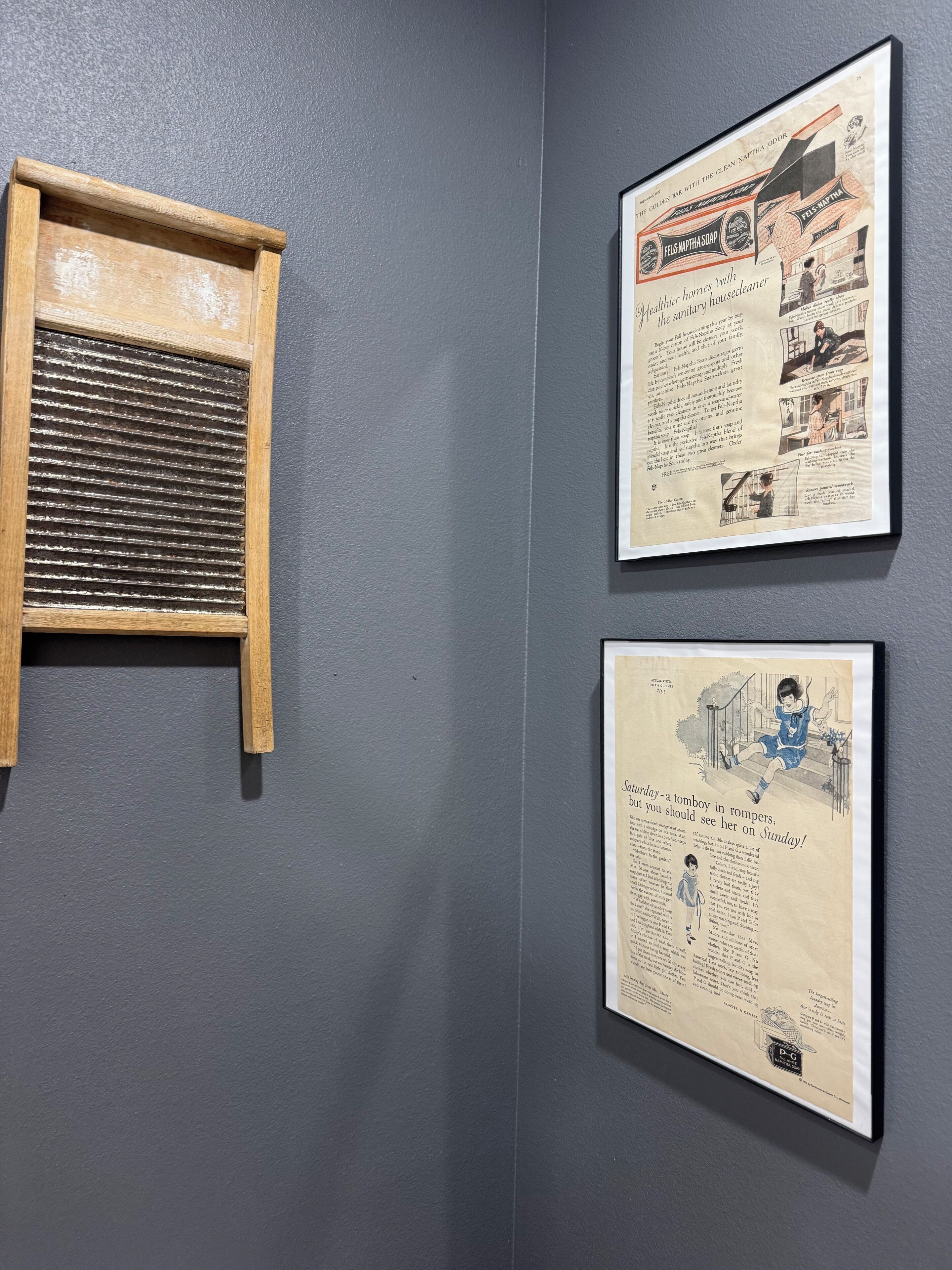 Two framed advertisements on a wall.