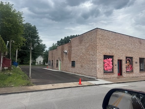 A brick building with a green door and a red awning, featuring a large red sign with the text 'BITE CLUB ALLBA MO'.