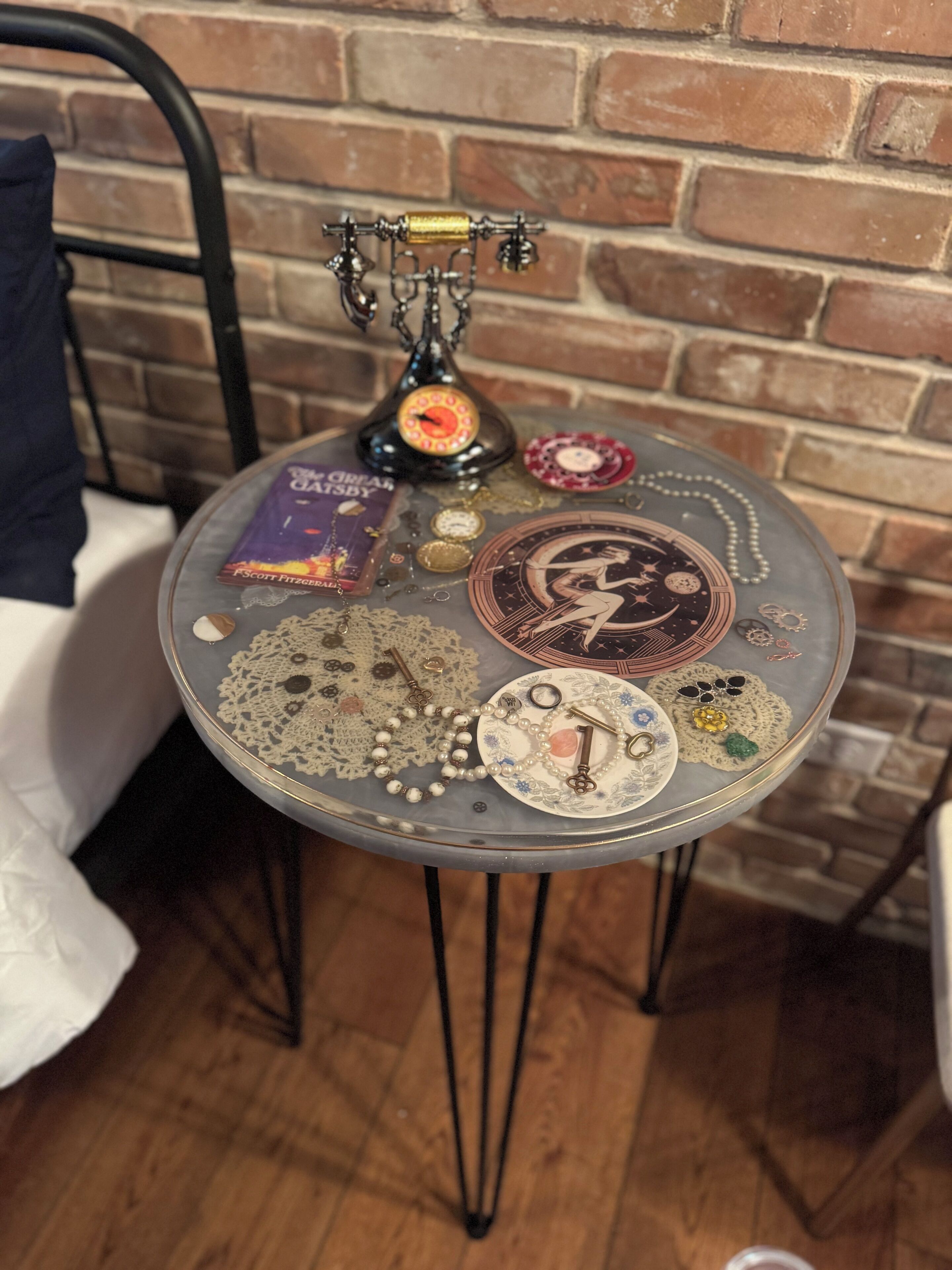 A round table with various decorative items including a book, a key, and a vintage telephone.