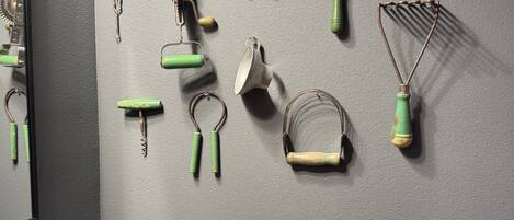A wall with various kitchen utensils and tools hanging on it.