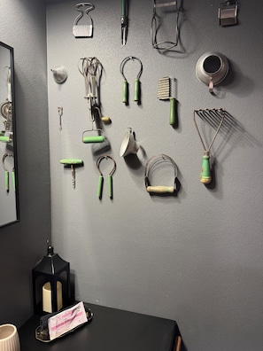 A wall with various kitchen utensils and tools hanging on it.