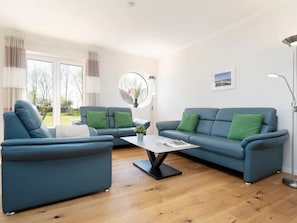 A modern living room with a blue sofa set, a coffee table, and a floor lamp. - Reiterhof Rickert Glücksklee by Interhome (Bannesdorf)