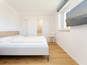 A bedroom with a bed, a chair, a window, and a door. - Reiterhof Rickert Glücksklee by Interhome (Bannesdorf)