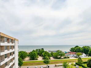 A residential area with a view of the sea, a multi-story building, and a parking lot. - Meeresblick Ankerplatz 84 by Interhome (Kellenhusen)