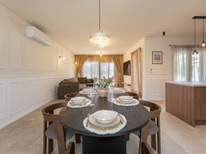 A dining area with a round table set for six, surrounded by wooden chairs. - Beautiful Villa Lorna with pool by Interhome (Biograd na Moru)