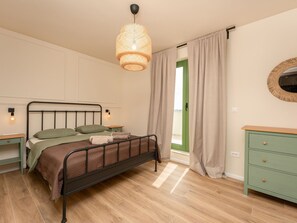 A bedroom with a bed, bedside lamps, a dresser, and a window with curtains. - Beautiful Villa Lorna with pool by Interhome (Biograd na Moru)