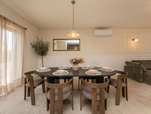 A dining room with a round table set for six, surrounded by wooden chairs. - Beautiful Villa Lorna with pool by Interhome (Biograd na Moru)