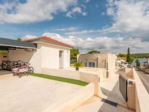 Ein Wohnhaus mit befestigter Auffahrt, überdachter Außenlounge und Meerblick.