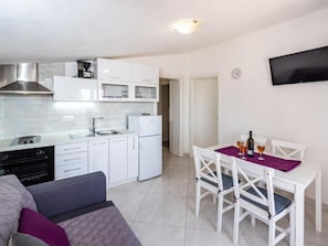 A compact kitchen with white cabinets, a built-in microwave, and a stainless steel range hood. - Holiday Home Tonka with pool by Interhome (Donje Rastane)