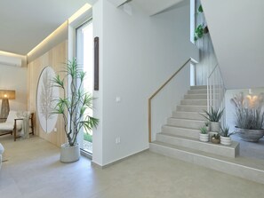 Ein modernes Interieur mit Treppe, Topfpflanzen und minimalistischer Gestaltung.