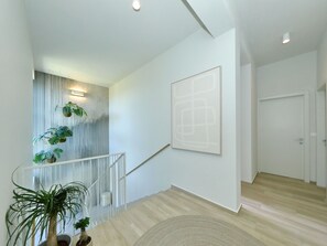 A modern interior with a staircase, a large abstract painting, and potted plants. - 5* Luxury villa La Casa with heated pool and sauna by Interhome (Zadar/Bibinje)