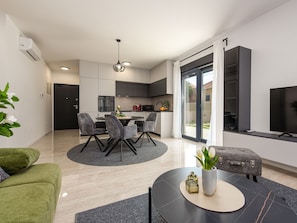 Eine moderne Wohnung mit Essbereich, Küche und Wohnraum.