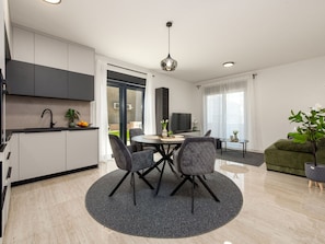 Ein modernes Apartment mit Küche, Essbereich und Wohnraum.