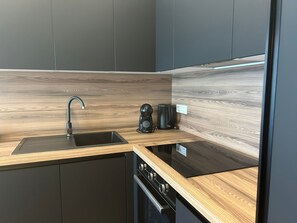 A modern kitchen with a wooden countertop, a sink, and a coffee machine. - Apartment Gold Shine by Interhome (Zadar)