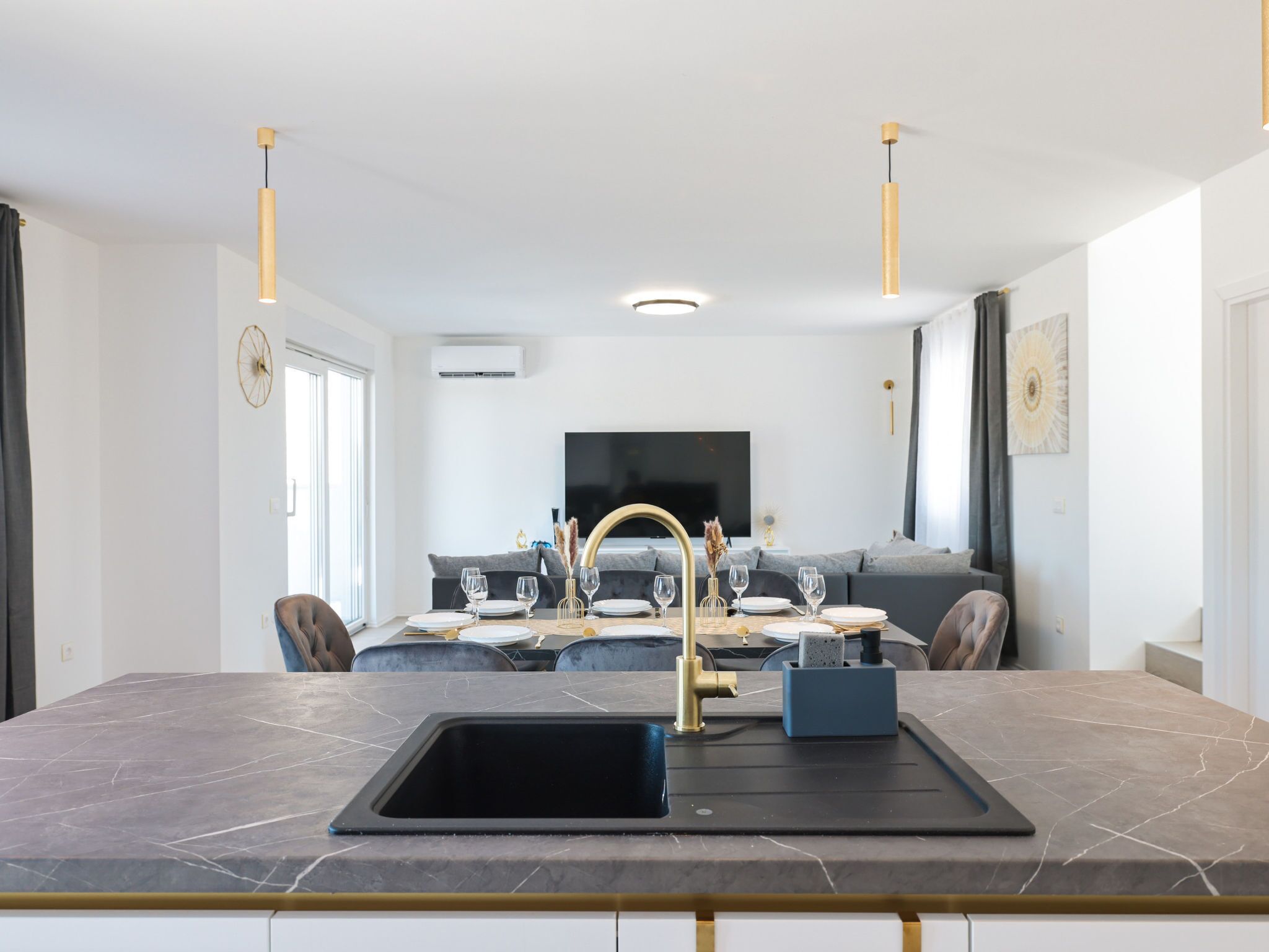 A modern kitchen with a central island, a built-in sink, and pendant lighting.