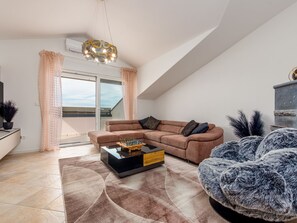 A modern living room with a sofa, a coffee table, and a decorative lamp. - Seaview apartment Casa Almaris A3 by Interhome (Zadar/Kožino)